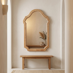 Vintage arched wood-framed mirror on a hallway wall above a bench
