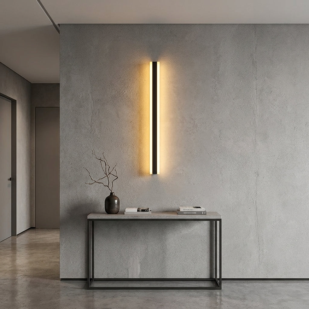 Short black linear LED bar wall light as a warm accent in a modern hallway