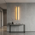 Short black linear LED bar wall light as a warm accent in a modern hallway