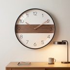 Modern Nordic wall clock, white dial with walnut band and full numerals, rose-gold hands, above a desk