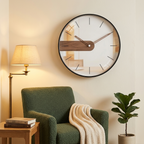 Modern Nordic wall clock with walnut accent and baton markers, rose-gold hands, in a reading corner