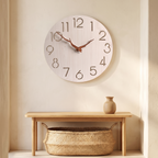 Light wood minimalist wall clock with cut-out numerals in an entryway