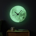Moon wall clock glowing soft green with airplane-tipped second hand in a dark bedroom, glow-in-the-dark dial