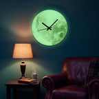 Moon wall clock with green glow-in-the-dark dial and airplane-tipped second hand in a cozy reading nook at night