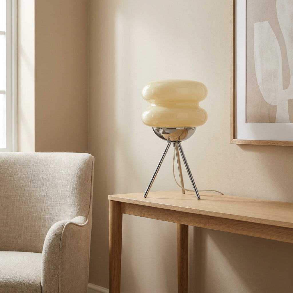 Two-tier stacked cream glass shade with a pinched waist on a slim chrome tripod base.