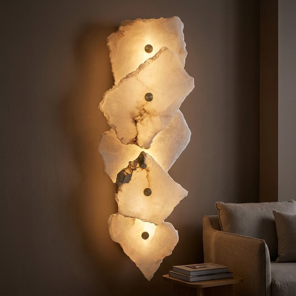 Detail of the small brass-tone fitting at the top of the translucent stone-look wall sconce.