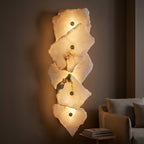 Detail of the small brass-tone fitting at the top of the translucent stone-look wall sconce.