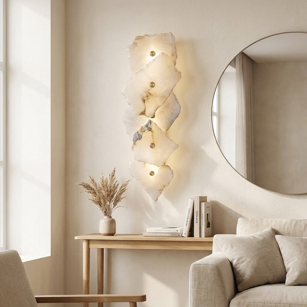 Tall, narrow stacked stone-look wall sconce lighting a hallway with a warm glow.