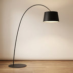 Arc floor lamp arching over a seating area, delivering soft overhead reading light
