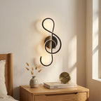 Nordic Music-Note LED Wall Sconce in black above a bedside nightstand