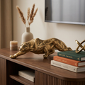 Gold prowling panther resin sculpture on a living room media console