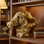 Gold panther resin sculpture in a descending pose on a study bookcase shelf