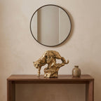 Antique-gold panther resin sculpture in a descending pose on an entryway console table with a round mirror