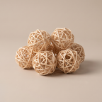 Natural rattan decorative balls clustered in a pale ceramic bowl on a coffee table