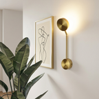 Gold wall sconce mounted in a hallway beside a framed art print