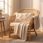 Cream tufted chevron lumbar cushion cover with corner tassels on a rattan armchair