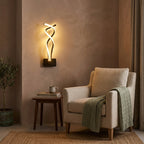Nordic Twisted-Ribbon LED Wall Sconce in black beside a reading chair