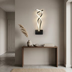 Nordic Twisted-Ribbon LED Wall Sconce in black on a hallway wall