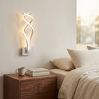 Nordic Twisted-Ribbon LED Wall Sconce in white above a bedside nightstand