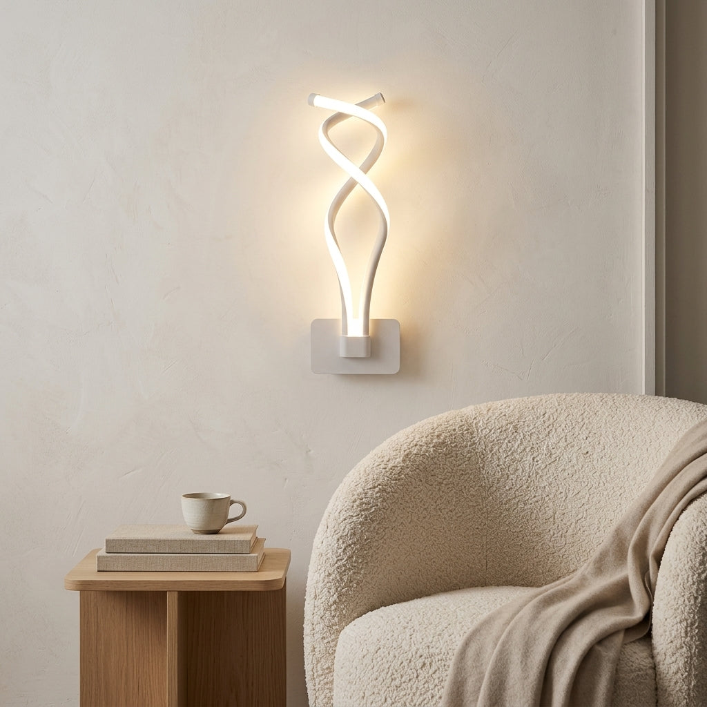 Nordic Twisted-Ribbon LED Wall Sconce in white beside a reading chair