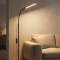 Slim LED floor lamp at dusk in a minimalist living room