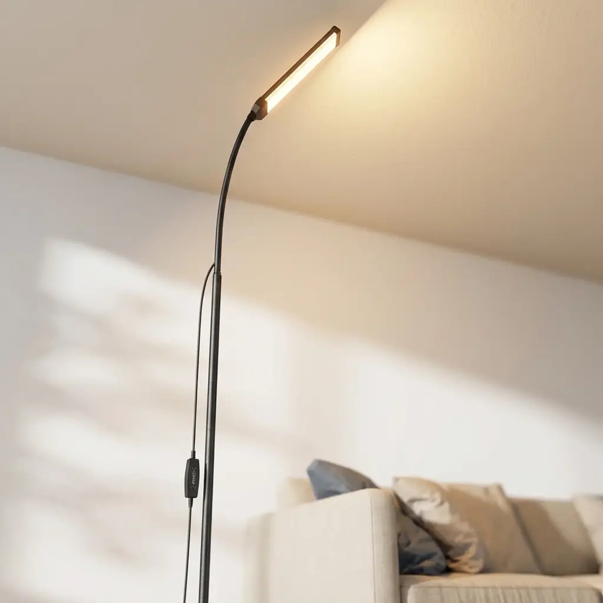 Matte black slim LED gooseneck floor lamp dramatic low-angle hero shot