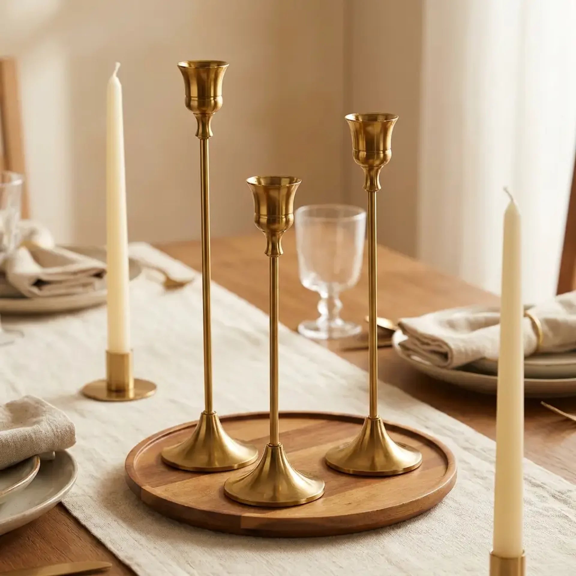 Set of three vintage tapered metal candle holders in graduated heights — as dining table centerpiece between candles