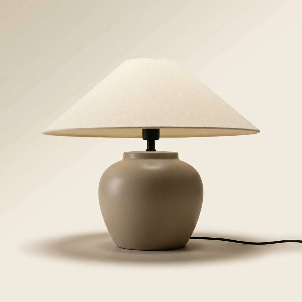 Close-up of the smooth matte oatmeal ceramic-look urn base and black neck of the table lamp.