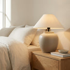 Wabi-sabi ceramic-look urn table lamp styled on a console table in a minimalist living room.