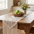Cream geometric macramé table runner on a farmhouse table with a bowl of apples