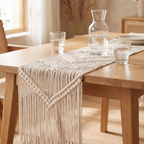 Cream geometric macramé table runner on an oak table with a glass carafe