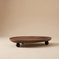 Wooden oval catchall tray with irregular edge holding keys on an entryway console