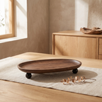 Minimalist wood catchall tray on a linen runner with a small dried stem